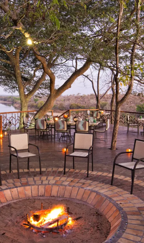 Riverside deck with fire pit and comfortable seating at dusk, Chilo Gorge Safari Lodge, Gonarezhou & Malilangwe, Zimbabwe
