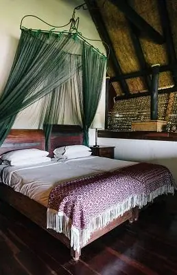 Bedroom with four-poster bed and green canopy drapes, Chilo Gorge Safari Lodge, Gonarezhou & Malilangwe, Zimbabwe