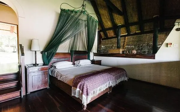 Bedroom with four-poster bed and green canopy drapes, Chilo Gorge Safari Lodge, Gonarezhou & Malilangwe, Zimbabwe