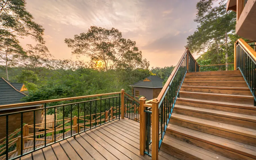 Wooden deck and stairs overlooking forested valley at sunset, Chimpundu Lodge, Kibale Forest, Uganda