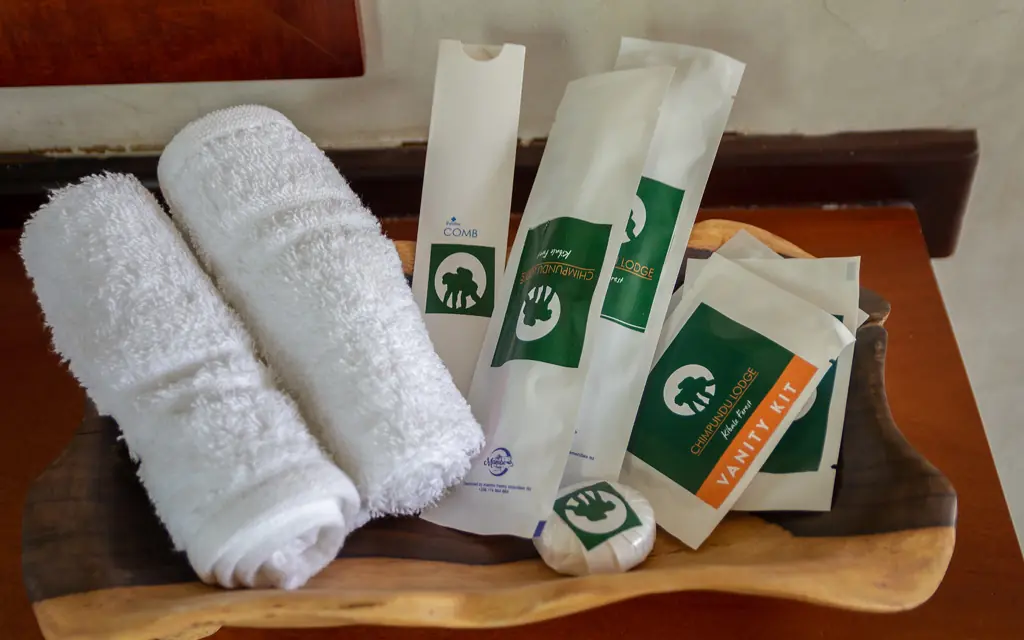White towels and amenity packages arranged on wooden tray, Chimpundu Lodge, Kibale Forest, Uganda