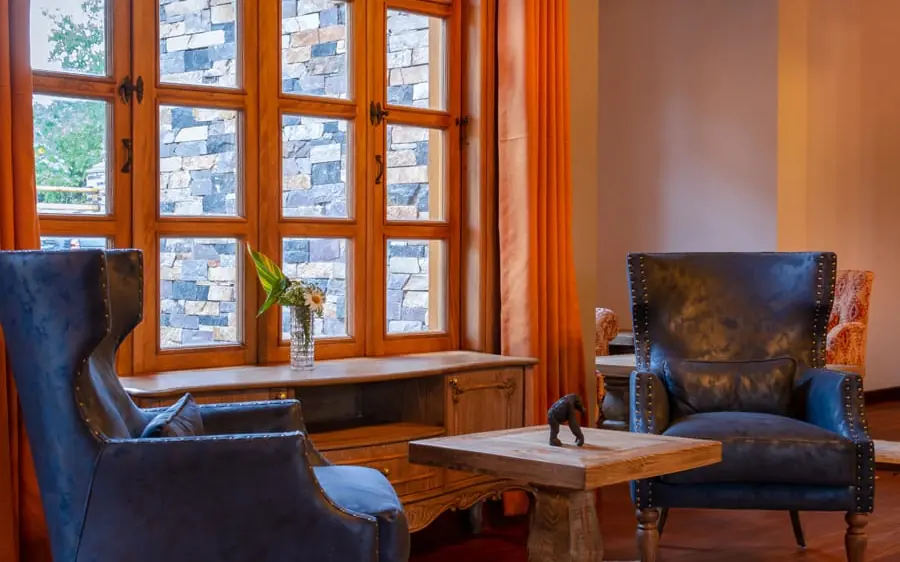 Luxury lounge with blue leather chairs and large windows, Chimpundu Lodge, Kibale Forest, Uganda