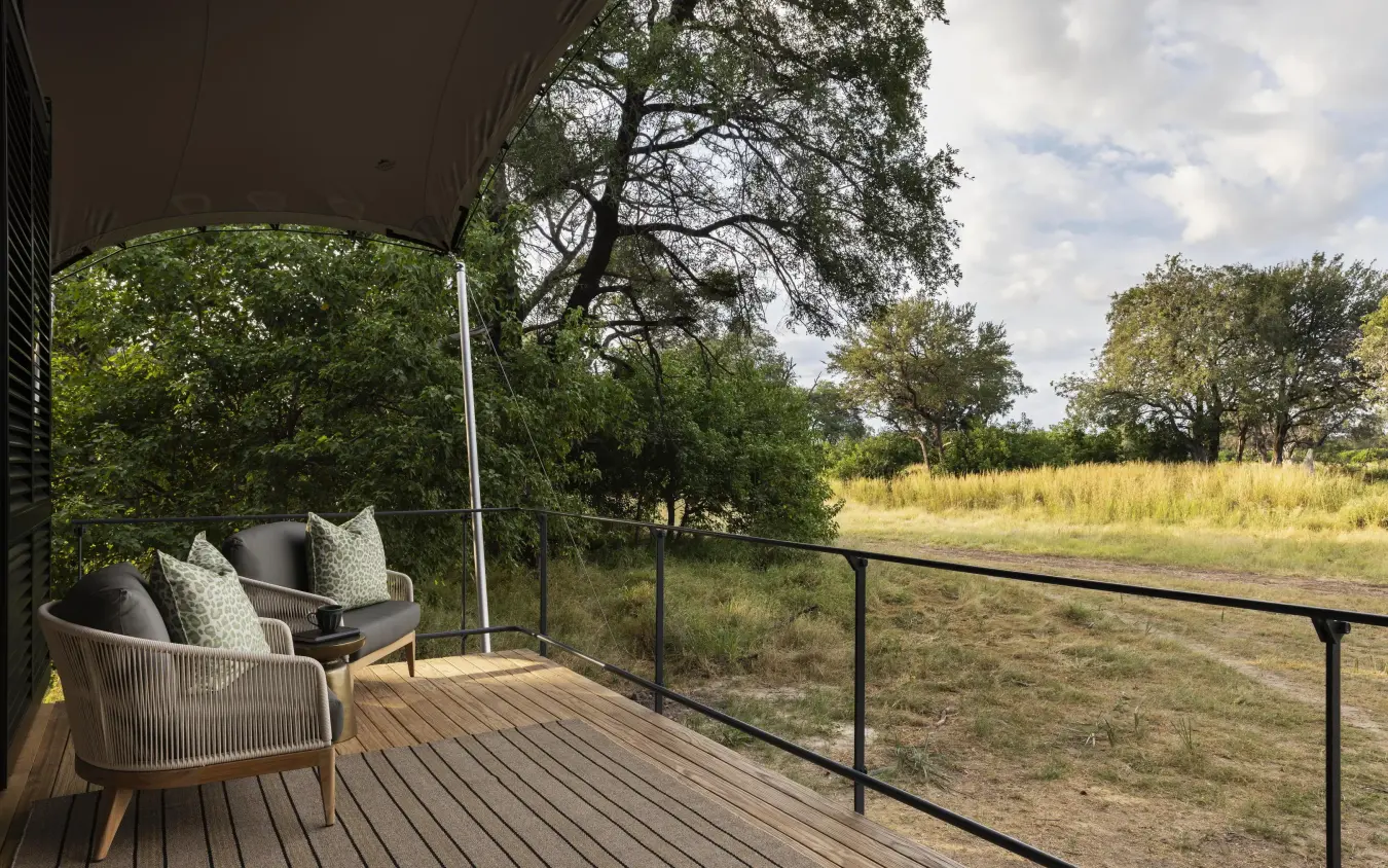 Wooden deck with chairs overlooking savanna landscape, Chitabe Camp, The Okavango Delta, Botswana