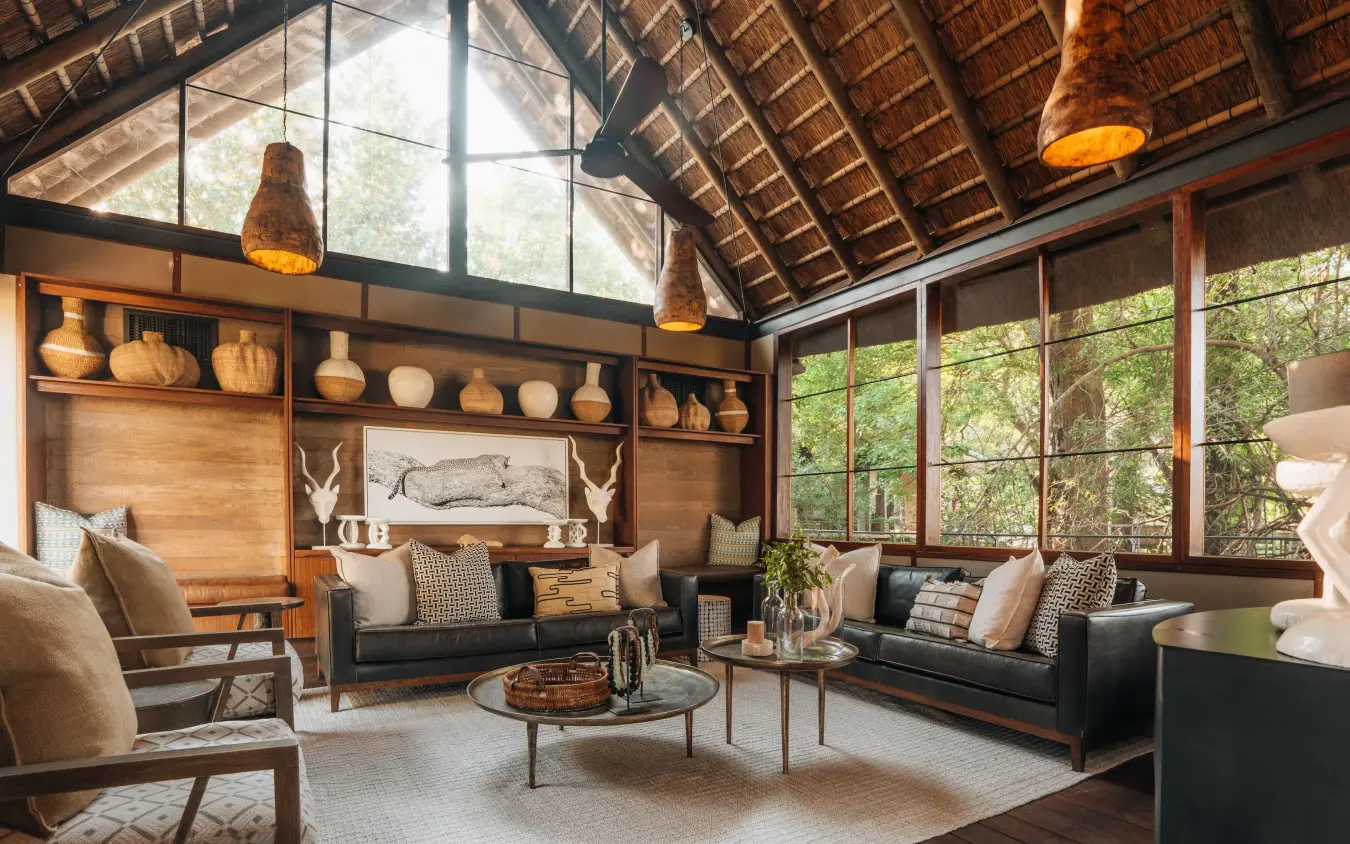 Safari lodge lounge with high ceilings and large windows overlooking trees, Chitabe Camp, The Okavango Delta, Botswana