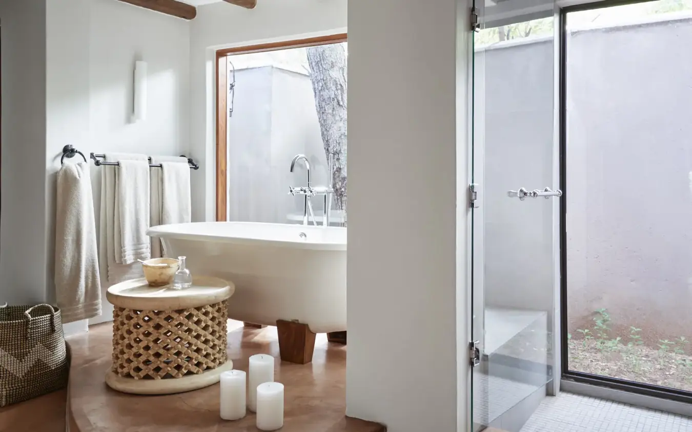 Luxury bathroom with freestanding tub and outdoor shower overlooking natural landscape, Chobe Chilwero, Chobe, Botswana