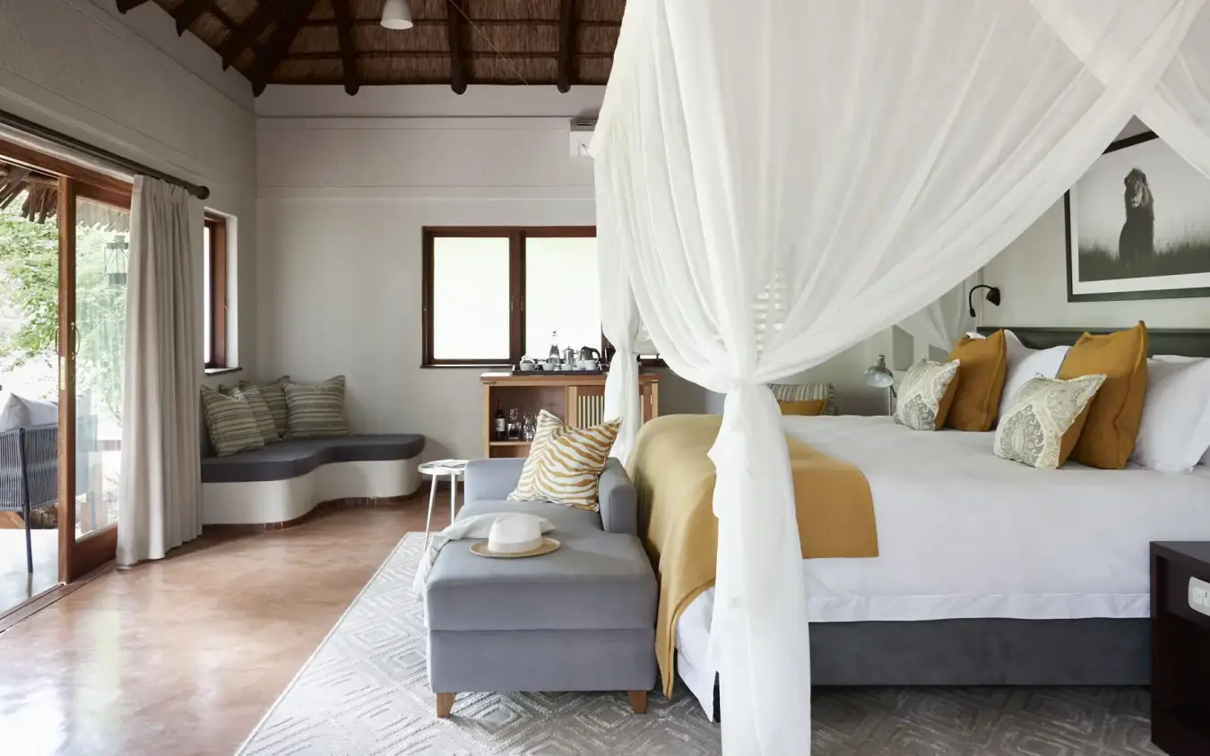 Luxury bedroom with four-poster bed and sheer white canopy in safari lodge, Chobe Chilwero, Chobe, Botswana