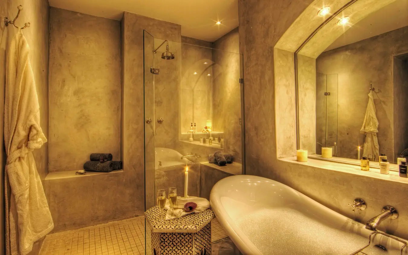 Luxury bathroom with freestanding tub and walk-in shower in warm stone tones, Chobe Game Lodge, Chobe, Botswana