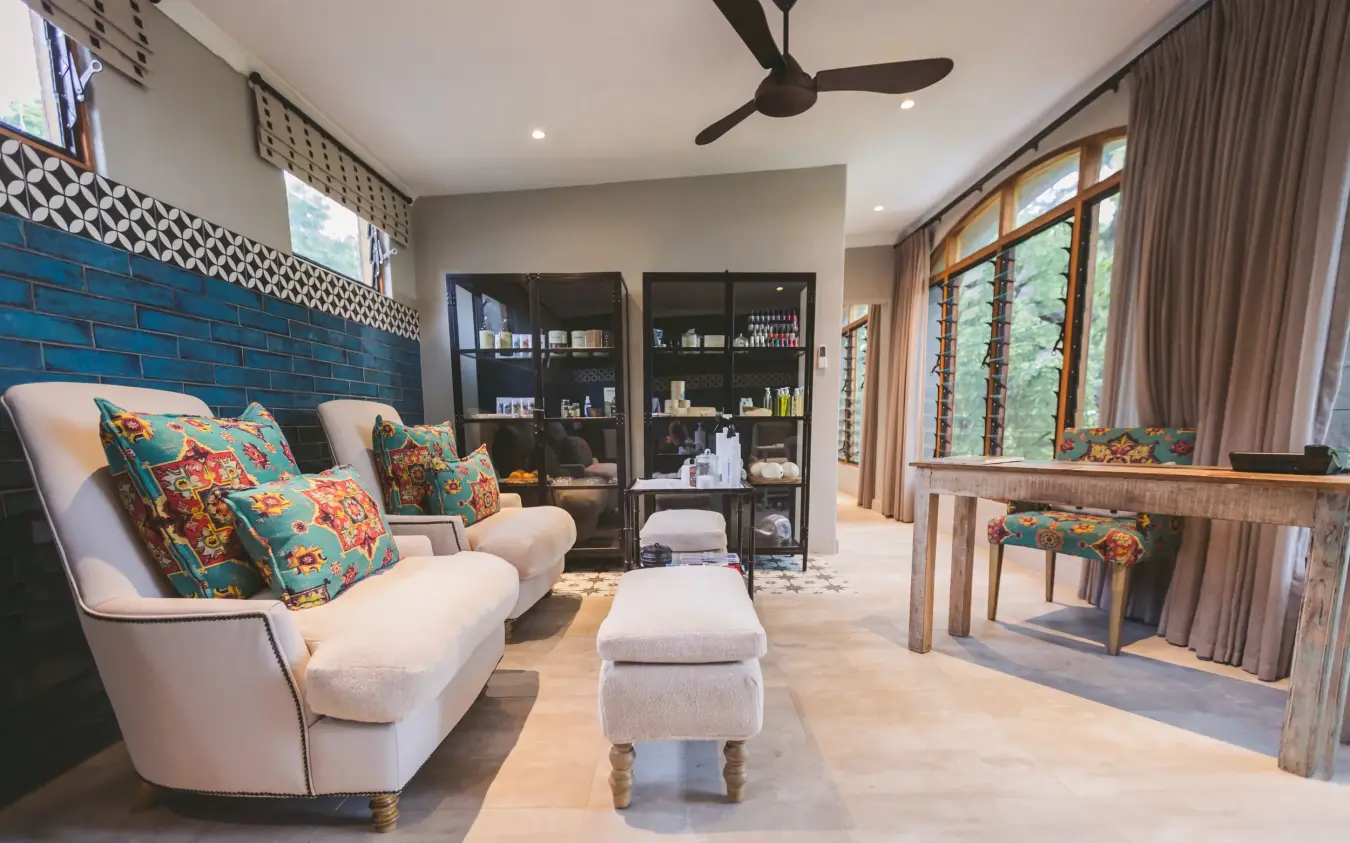 Luxury lounge interior with blue brick wall and colorful patterned cushions, Chobe Game Lodge, Chobe, Botswana
