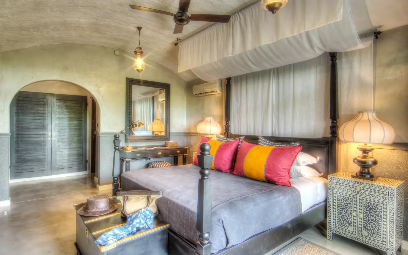 Luxury bedroom with four-poster bed and colorful cushions in safari lodge, Chobe Game Lodge, Chobe, Botswana