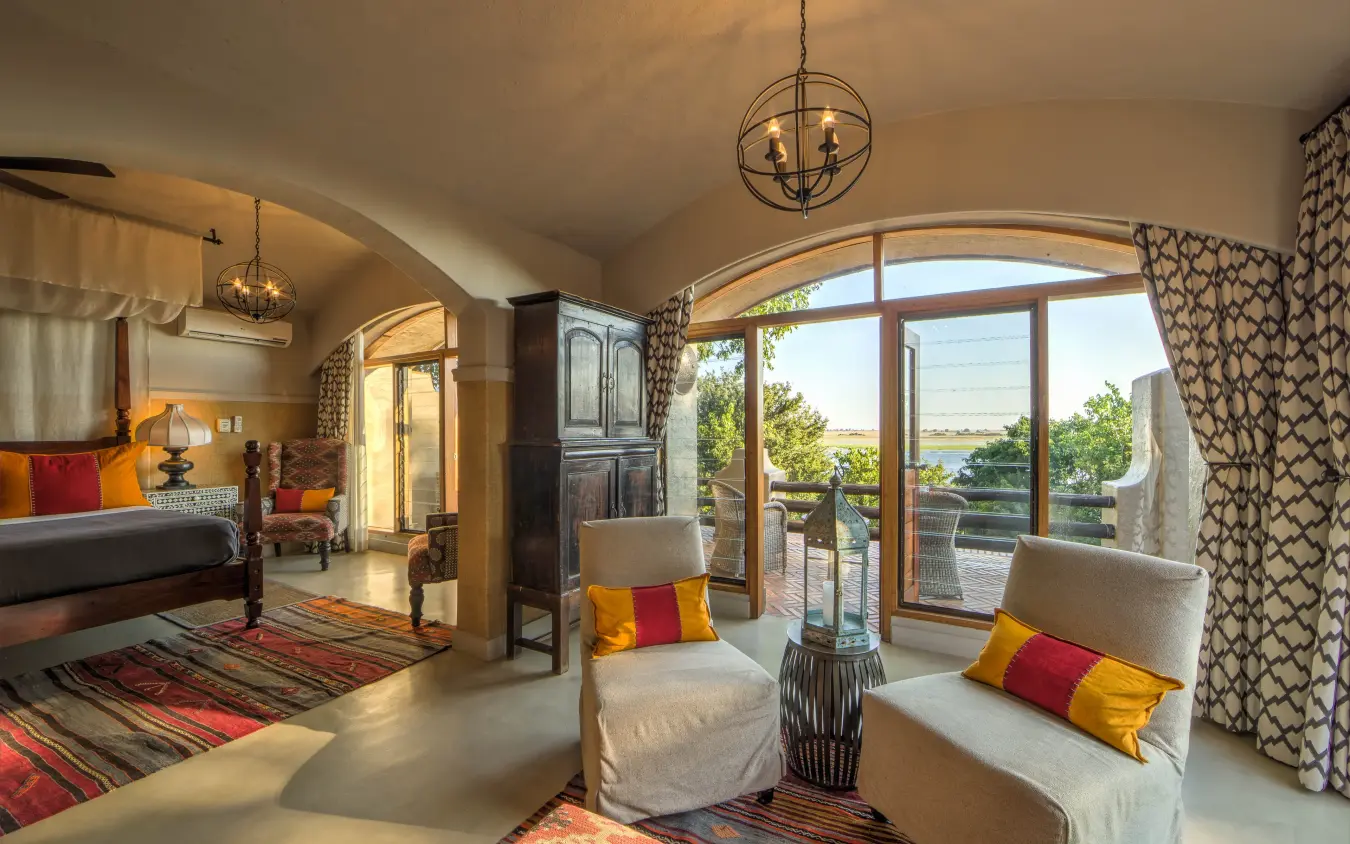 Luxury bedroom suite with waterfront views and contemporary furnishings, Chobe Game Lodge, Chobe, Botswana