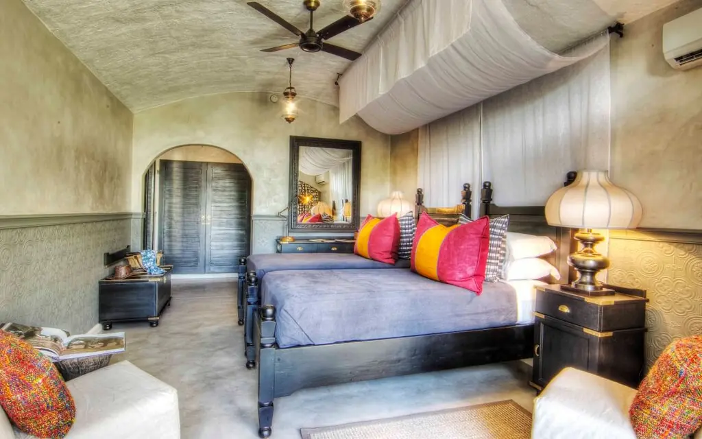 Luxury bedroom with colorful pillows and draped ceiling in safari lodge, Chobe Game Lodge, Chobe, Botswana