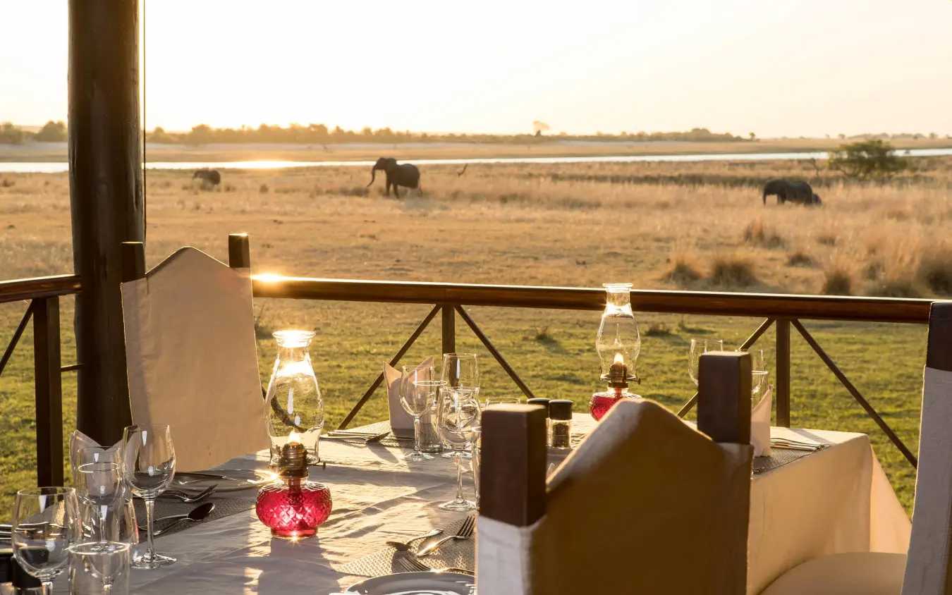 Dining deck overlooking savannah with grazing elephants, Chobe Savanna Lodge, Zambezi Region, Namibia