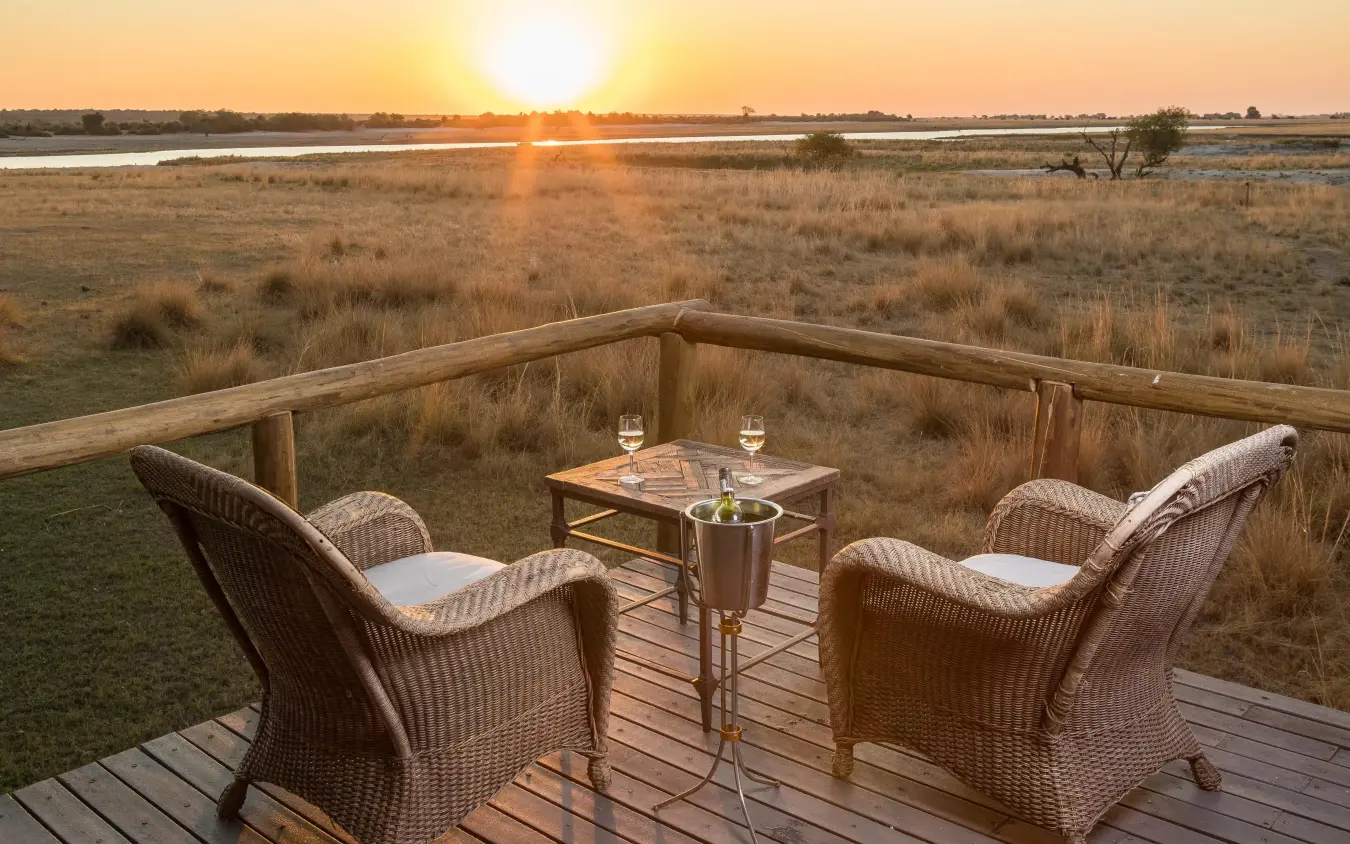 Wooden deck with chairs overlooking savanna at sunset, Chobe Savanna Lodge, Zambezi Region, Namibia