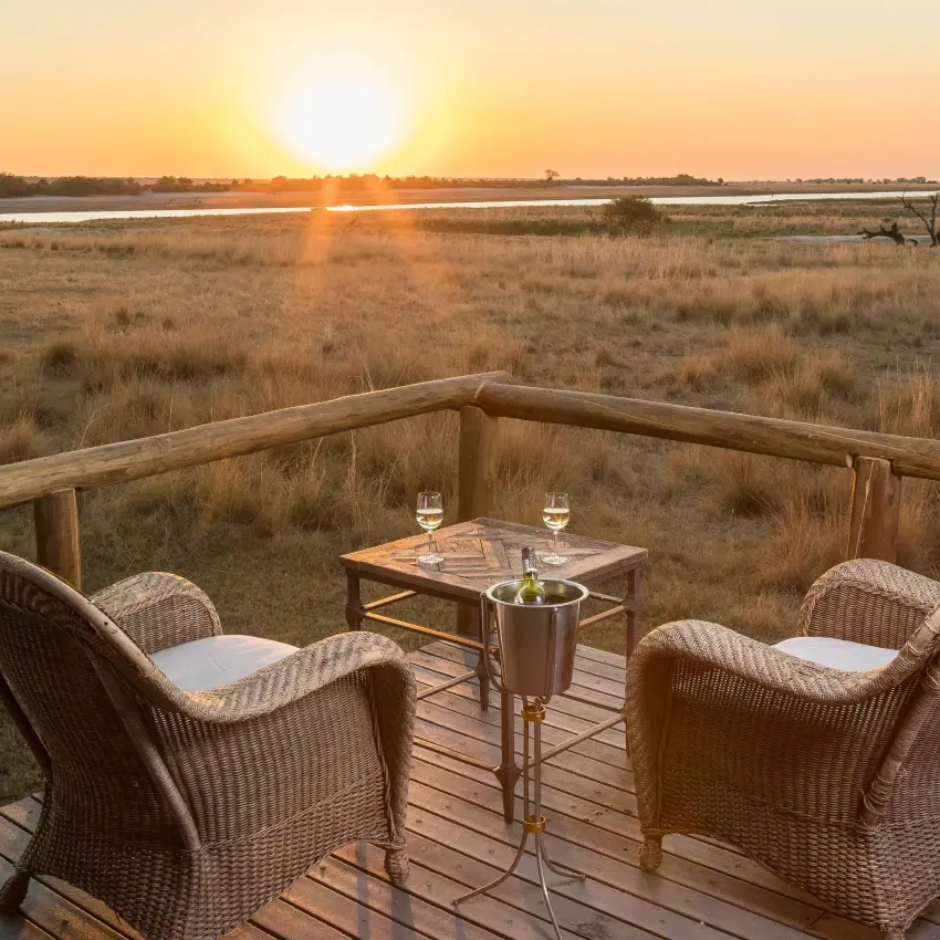 Wooden deck with chairs overlooking savanna at sunset, Chobe Savanna Lodge, Zambezi Region, Namibia