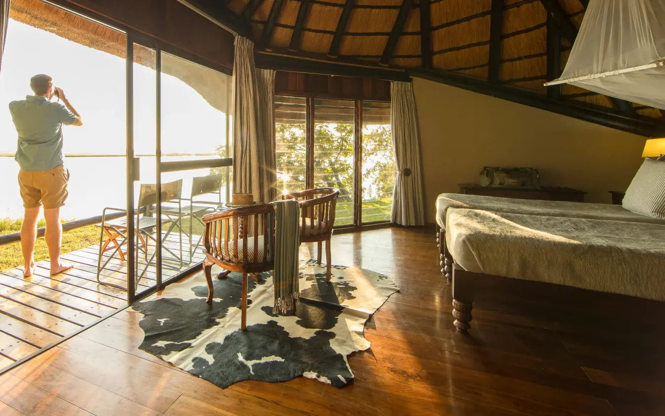 Guest standing on deck overlooking savannah landscape, Chobe Savanna Lodge, Zambezi Region, Namibia