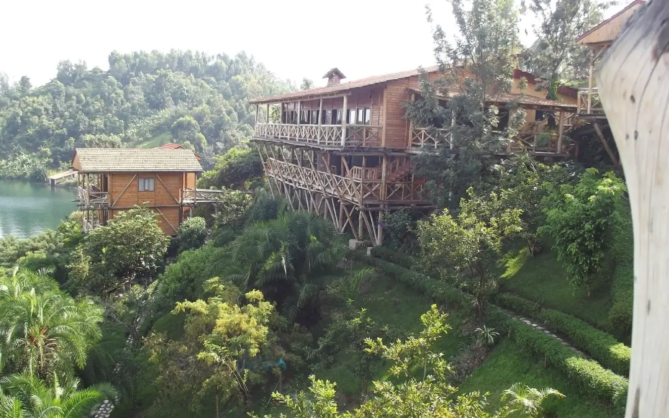 Riverside lodge structures nestled among dense tropical vegetation, Cormoran Lodge, Lake Kivu, Rwanda