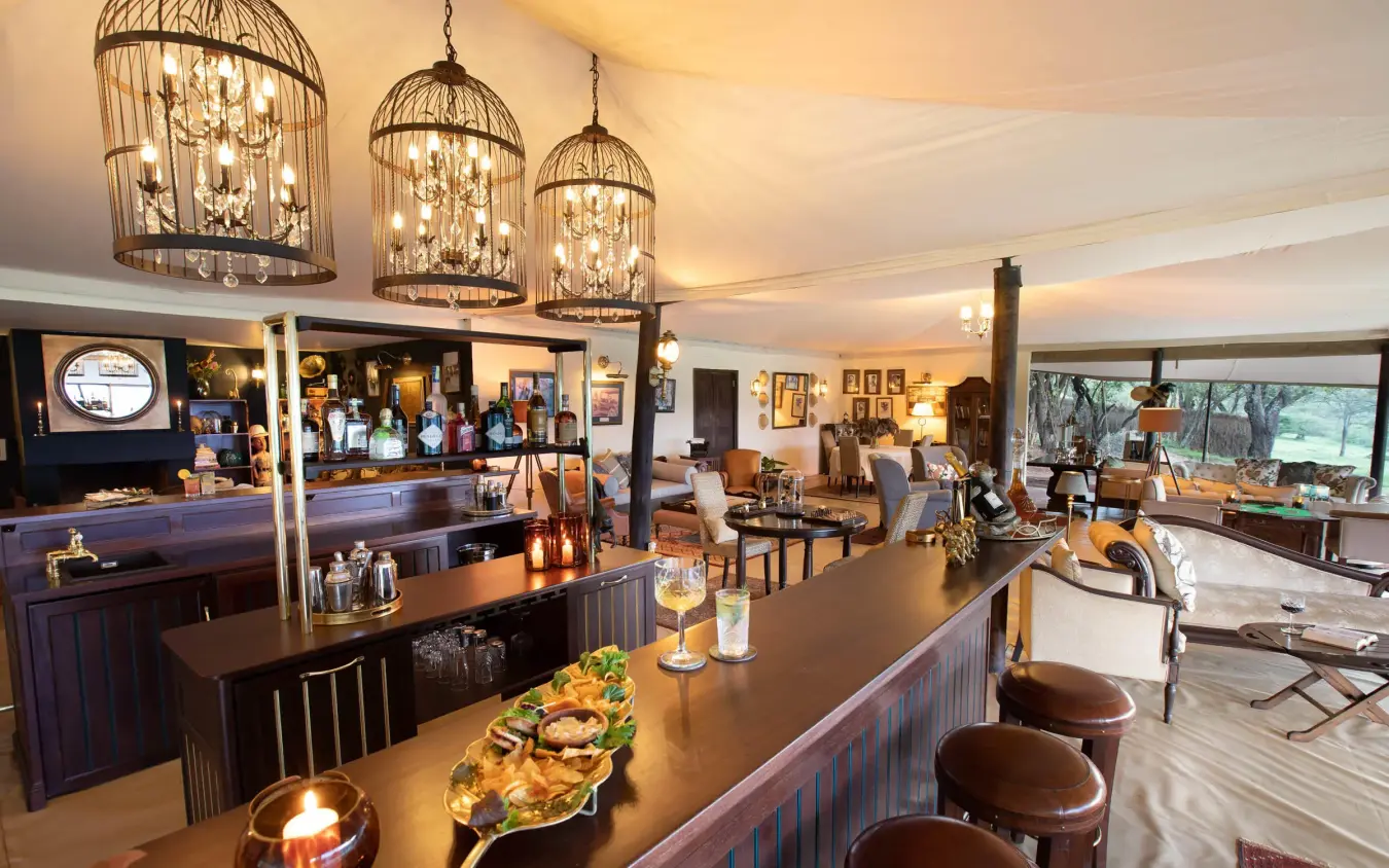 Interior lounge with bar counter and pendant lighting fixtures, Cottar’s 1920s Camp, Maasai Mara, Kenya