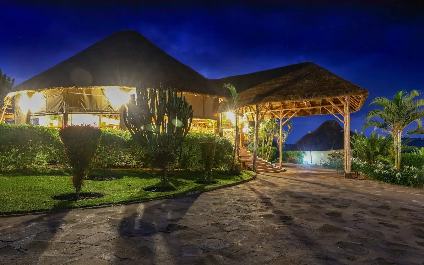 Illuminated safari lodge buildings at dusk with manicured grounds, Crater Safari Lodge, Kibale Forest, Uganda