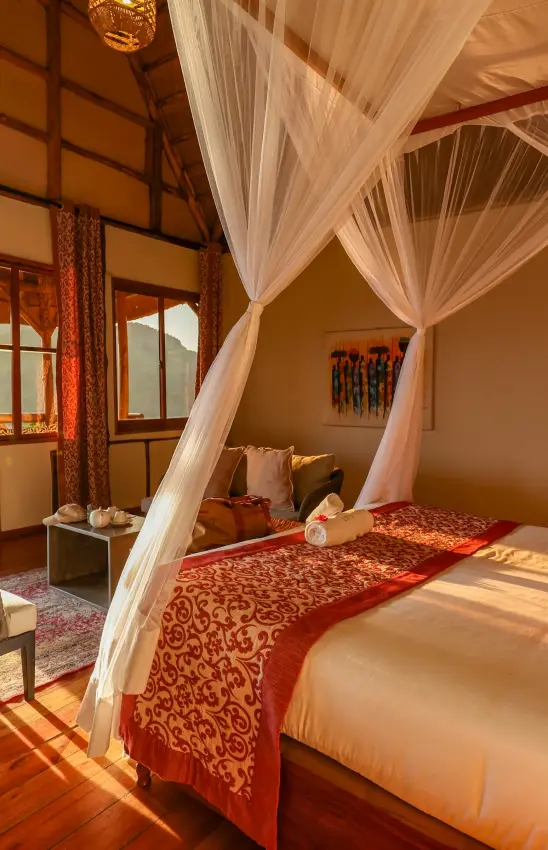 Bedroom with canopy bed overlooking water view, Crater Safari Lodge, Kibale Forest, Uganda