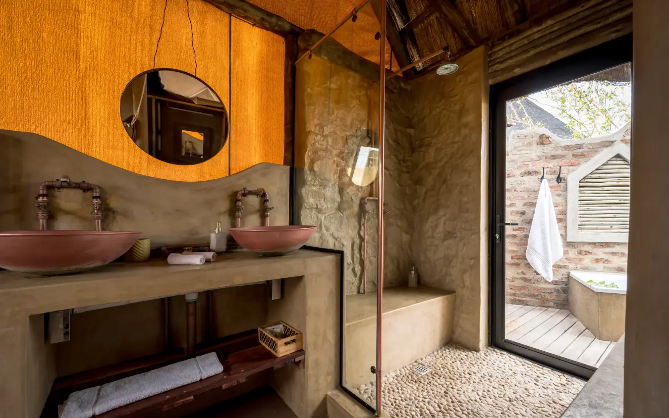 Luxury bathroom with twin sinks and outdoor shower overlooking courtyard, Daka Plains Camp, Hwange National Park, Zimbabwe