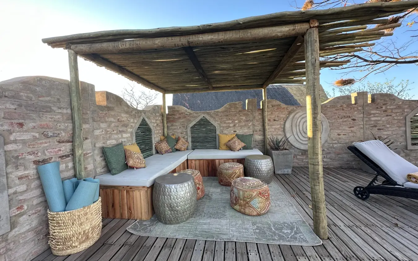 Rooftop lounge area with wooden pergola and woven seating overlooking desert landscape, Daka Plains Camp, Hwange National Park, Zimbabwe