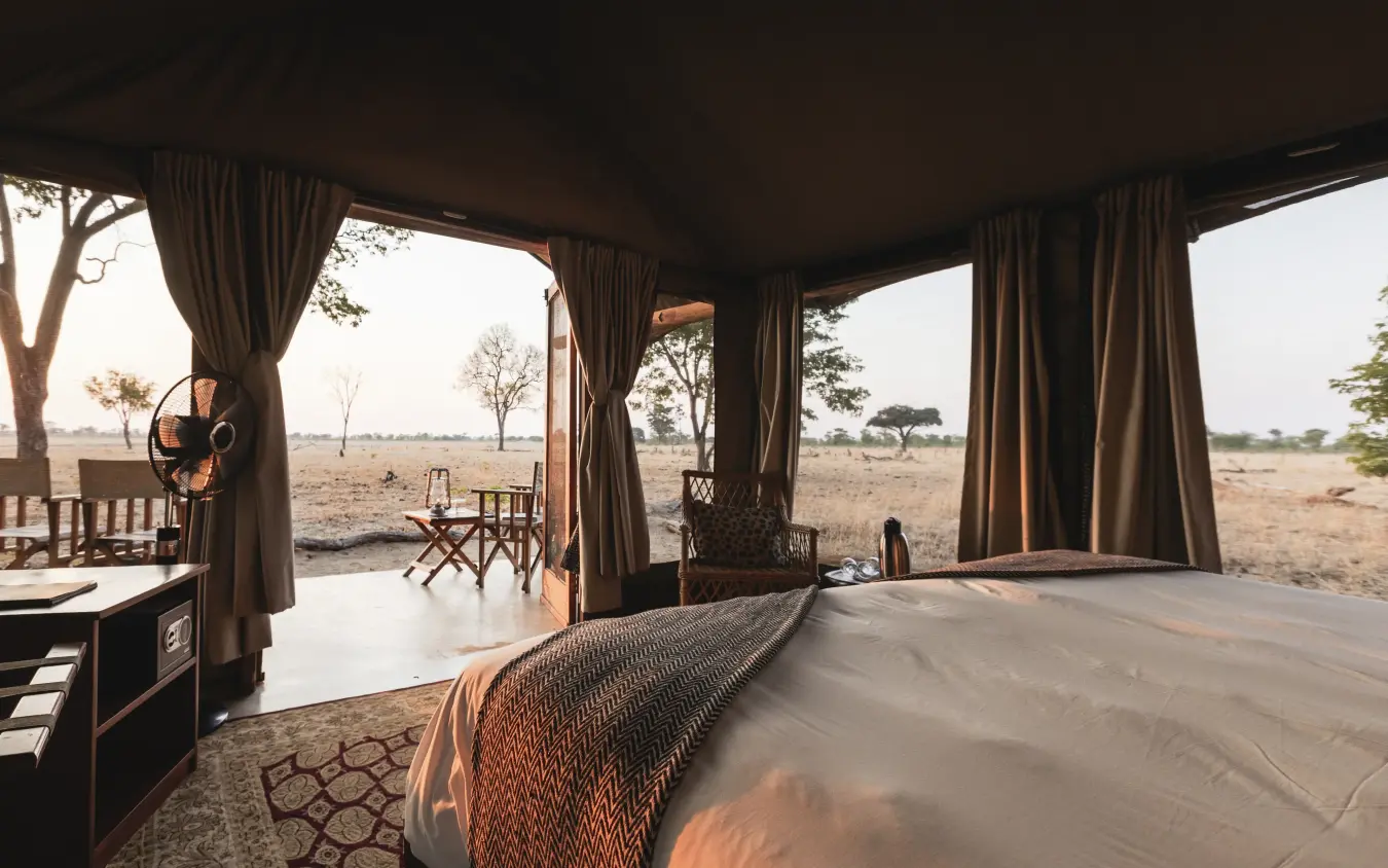 Luxury safari tent interior with panoramic savanna views at dusk, Davison’s Camp, Hwange National Park, Zimbabwe