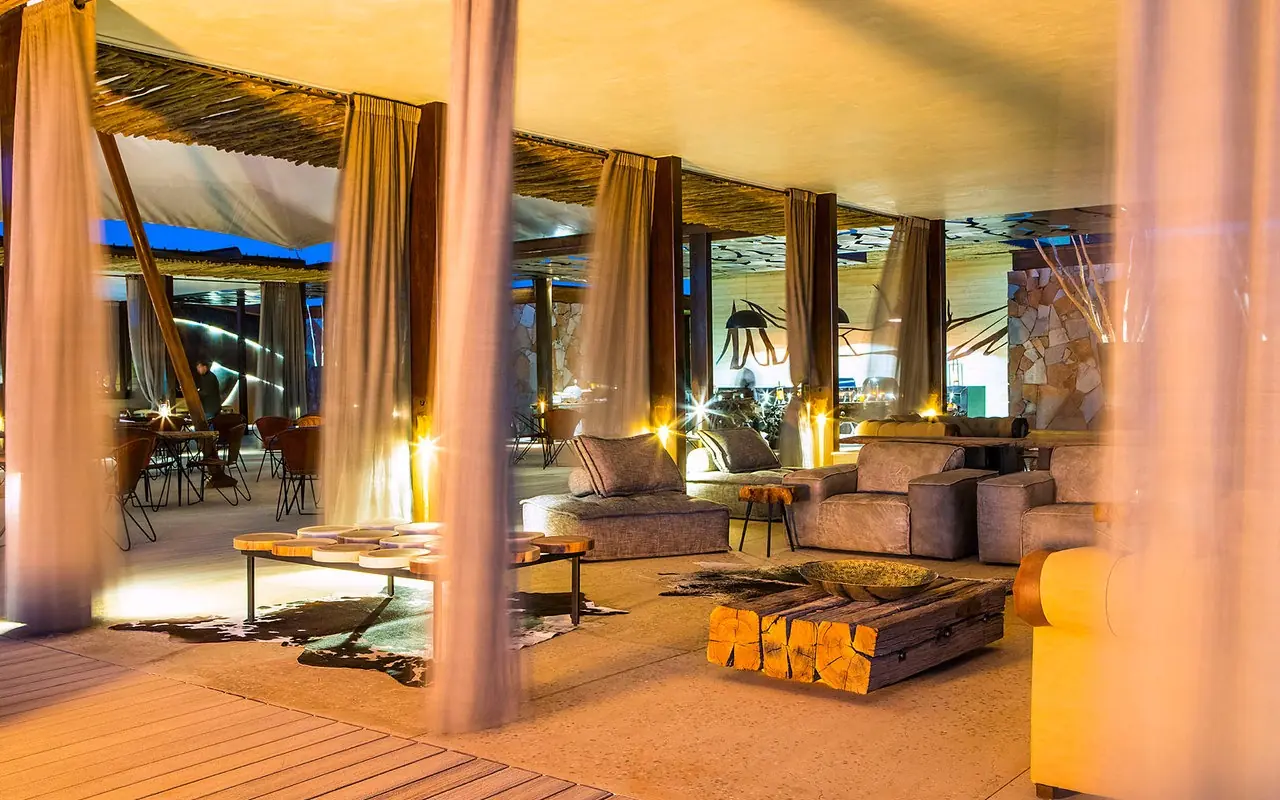 Modern lounge area with seating and viewing windows at dusk, Dead Valley Lodge, Sossusvlei, Namibia