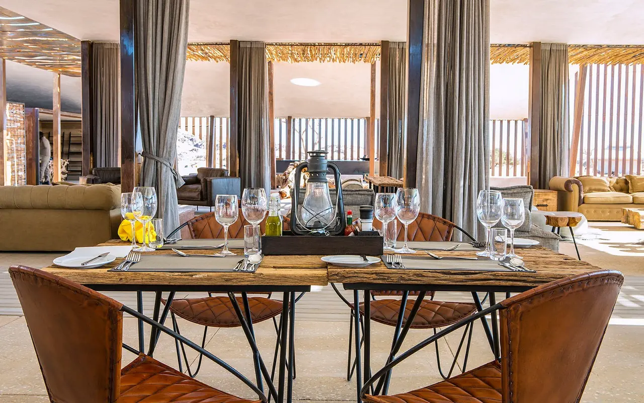 Dining table set with glassware overlooking desert landscape, Dead Valley Lodge, Sossusvlei, Namibia