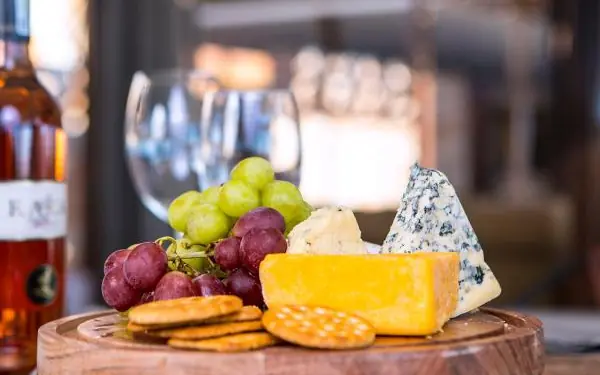 Cheese and grapes arranged on wooden board with wine, Dead Valley Lodge, Sossusvlei, Namibia