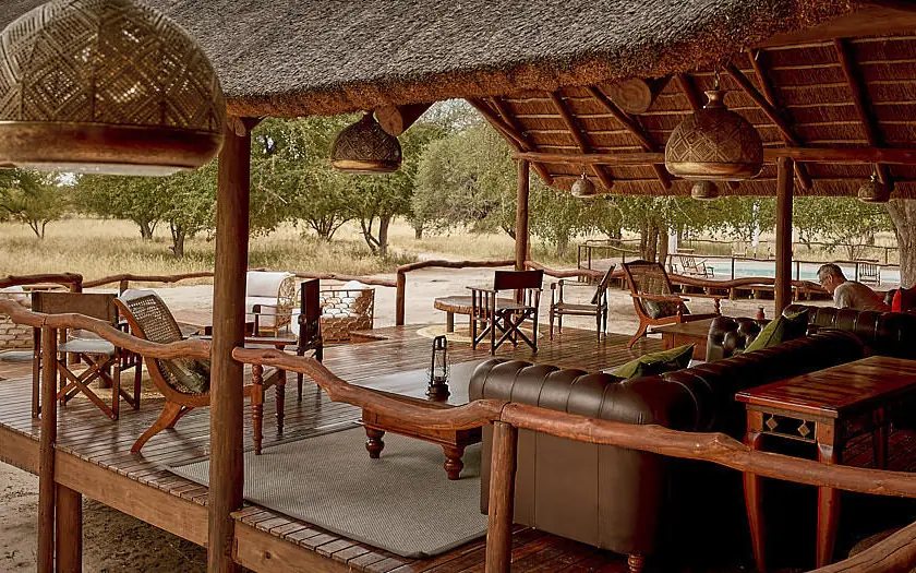Open-air lounge pavilion with wooden furnishings and views, Deception Valley Lodge, Central Kalahari, Botswana