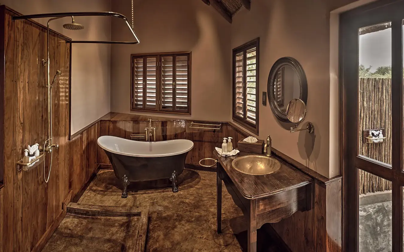 Luxury bathroom with freestanding tub and wooden finishes, Deception Valley Lodge, Central Kalahari, Botswana
