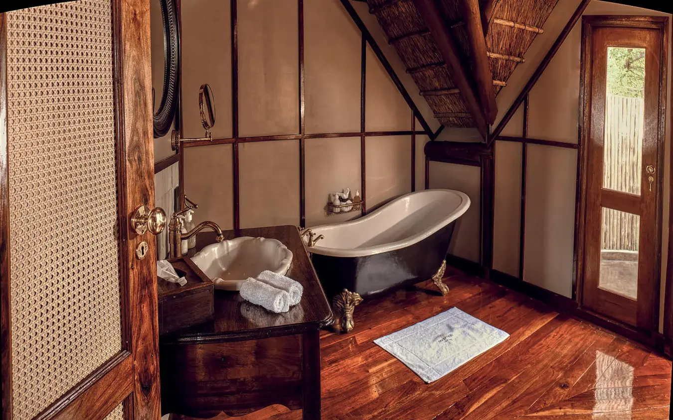 Luxury bathroom with freestanding tub and wooden flooring, Deception Valley Lodge, Central Kalahari, Botswana