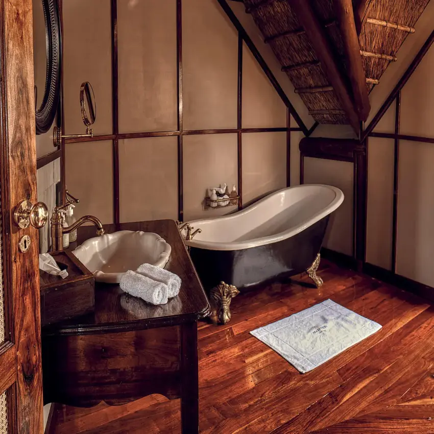 Luxury bathroom with freestanding tub and wooden flooring, Deception Valley Lodge, Central Kalahari, Botswana