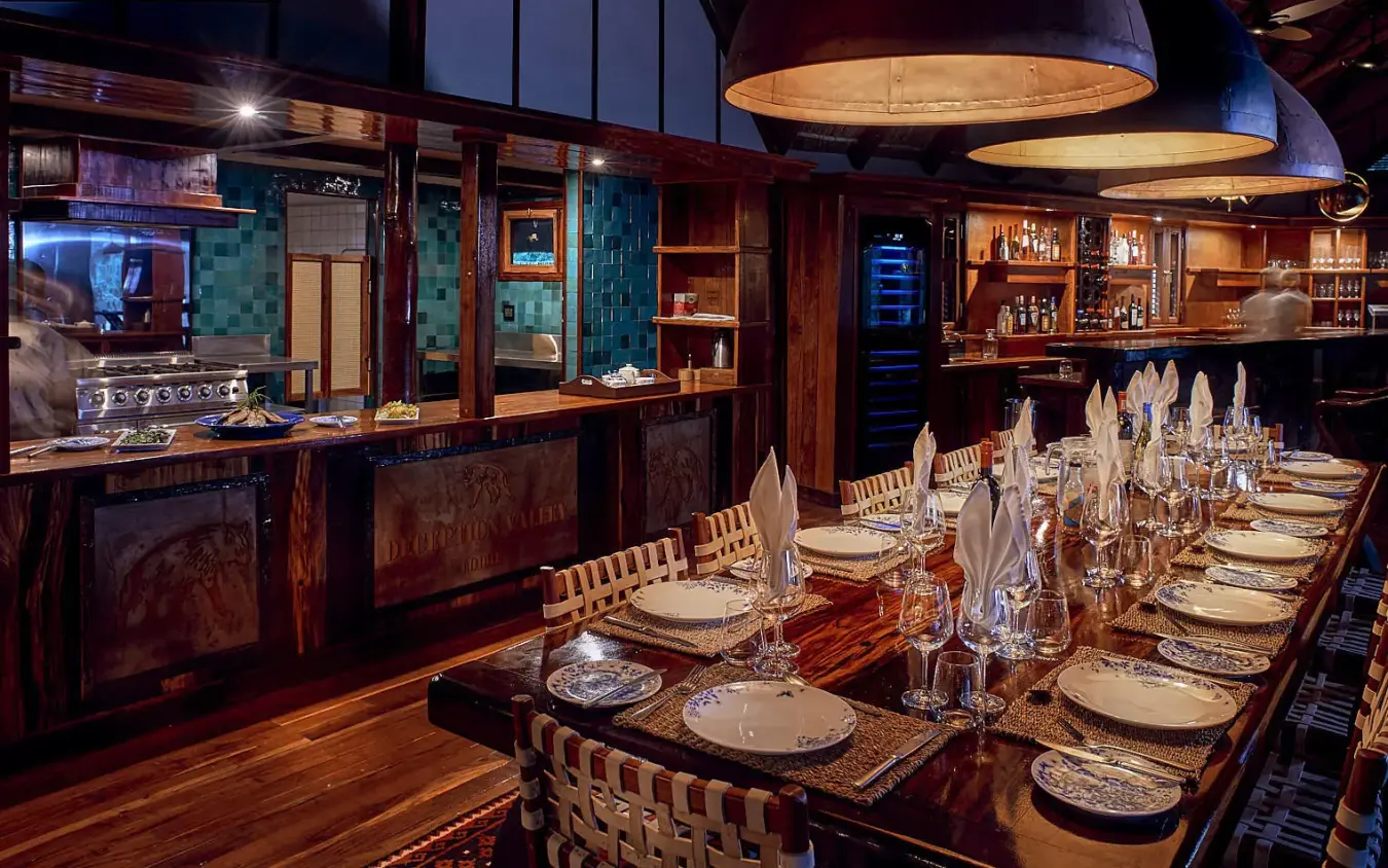 Fine dining room with long table setup and bar, Deception Valley Lodge, Central Kalahari, Botswana