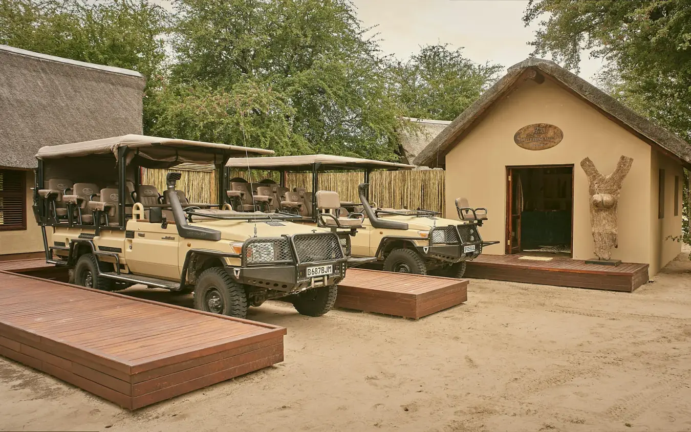 Safari lodge buildings with game drive vehicles parked outside, Deception Valley Lodge, Central Kalahari, Botswana