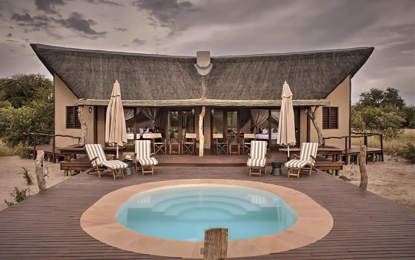 Circular pool with loungers and umbrella-covered seating area, Deception Valley Lodge, Central Kalahari, Botswana
