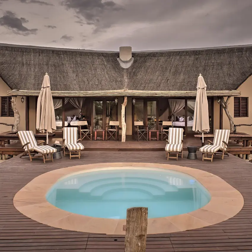 Circular pool with loungers and umbrella-covered seating area, Deception Valley Lodge, Central Kalahari, Botswana