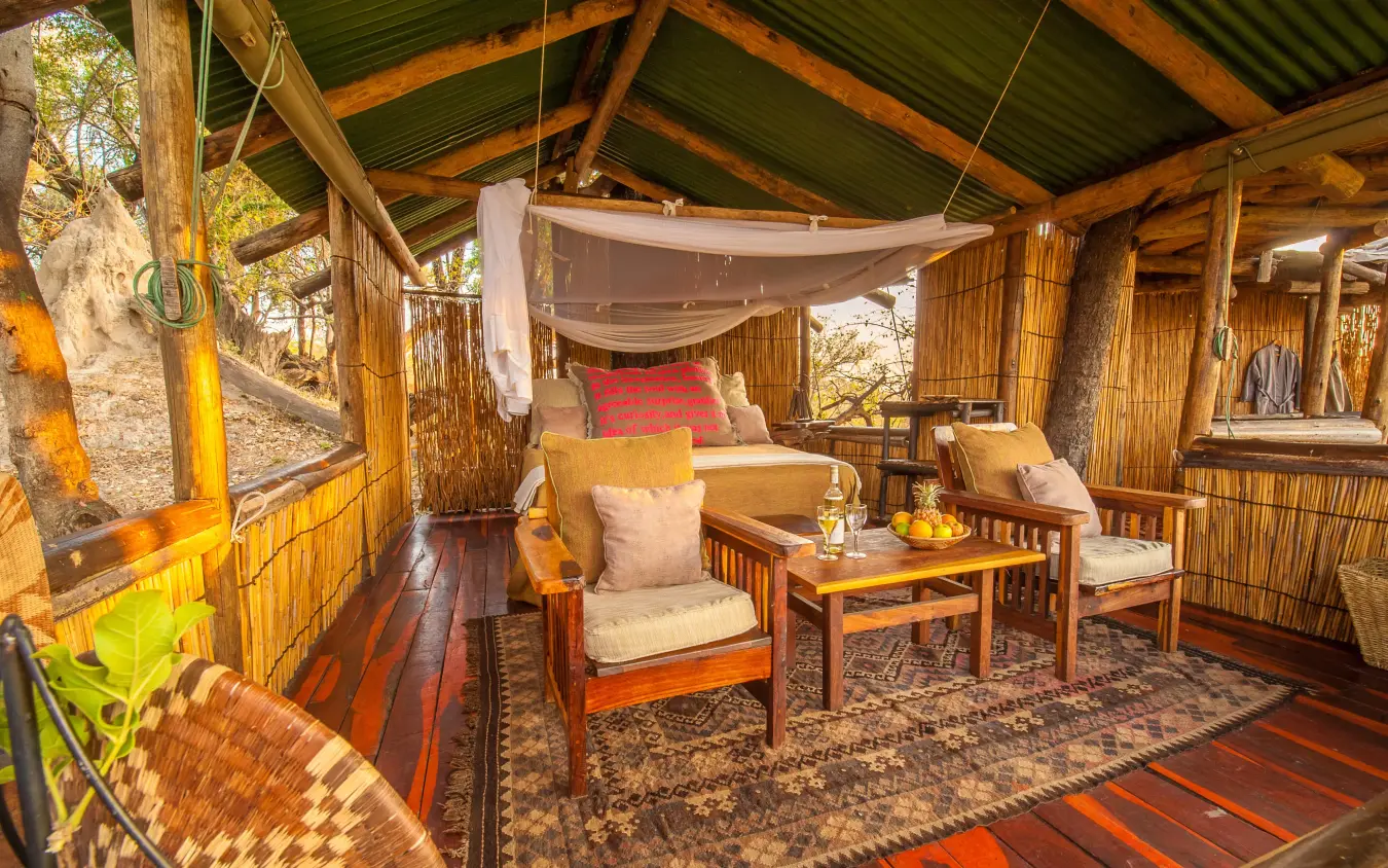 Wooden deck lounge with comfortable seating and draped canopy, Delta Camp, The Okavango Delta, Botswana