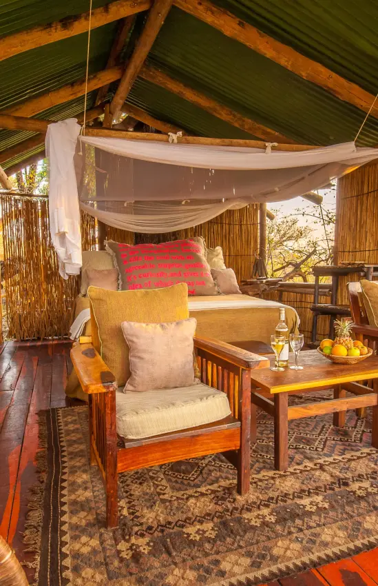 Wooden deck lounge with comfortable seating and draped canopy, Delta Camp, The Okavango Delta, Botswana