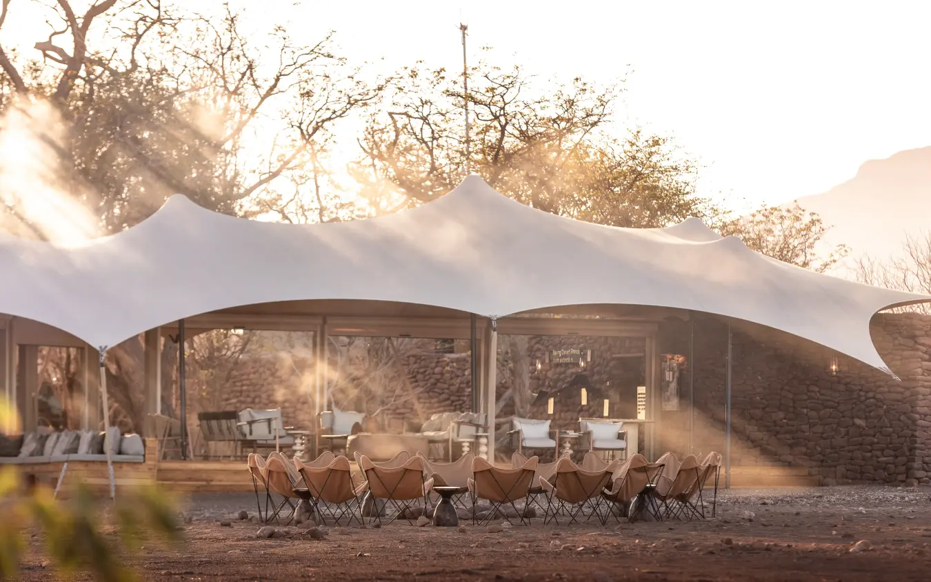 Luxury safari camp with canvas tent and outdoor seating at sunset, Desert Rhino Camp, Damaraland, Namibia