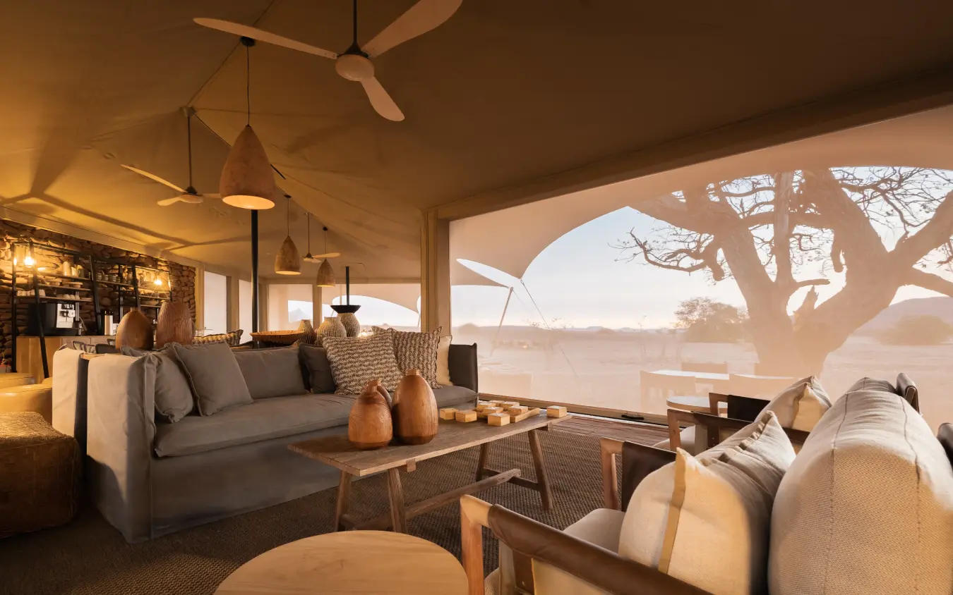 Open-sided lodge lounge with savanna views and scattered acacia trees, Desert Rhino Camp, Damaraland, Namibia