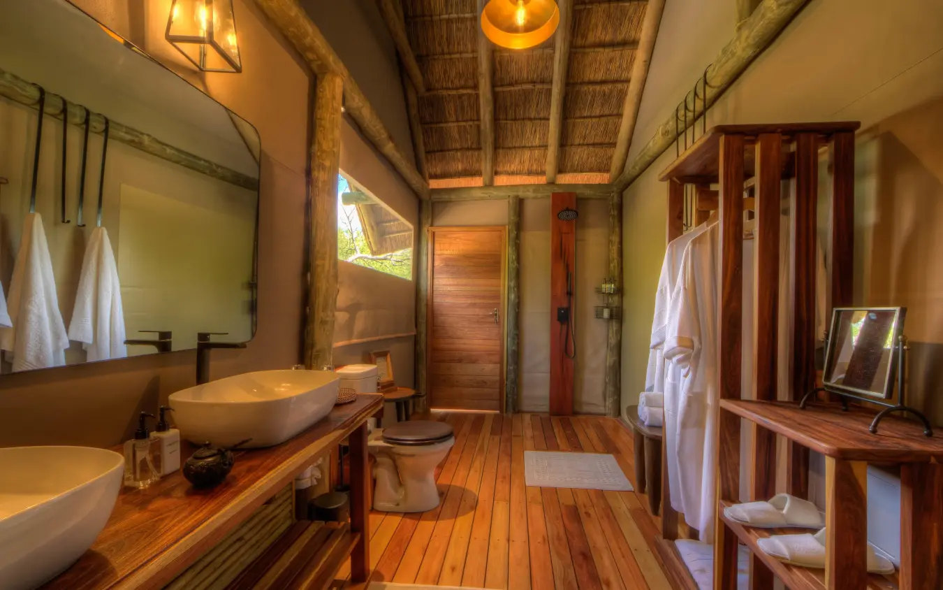 Spacious bathroom with wooden vanity and vessel sinks, Dinaka, Central Kalahari, Botswana