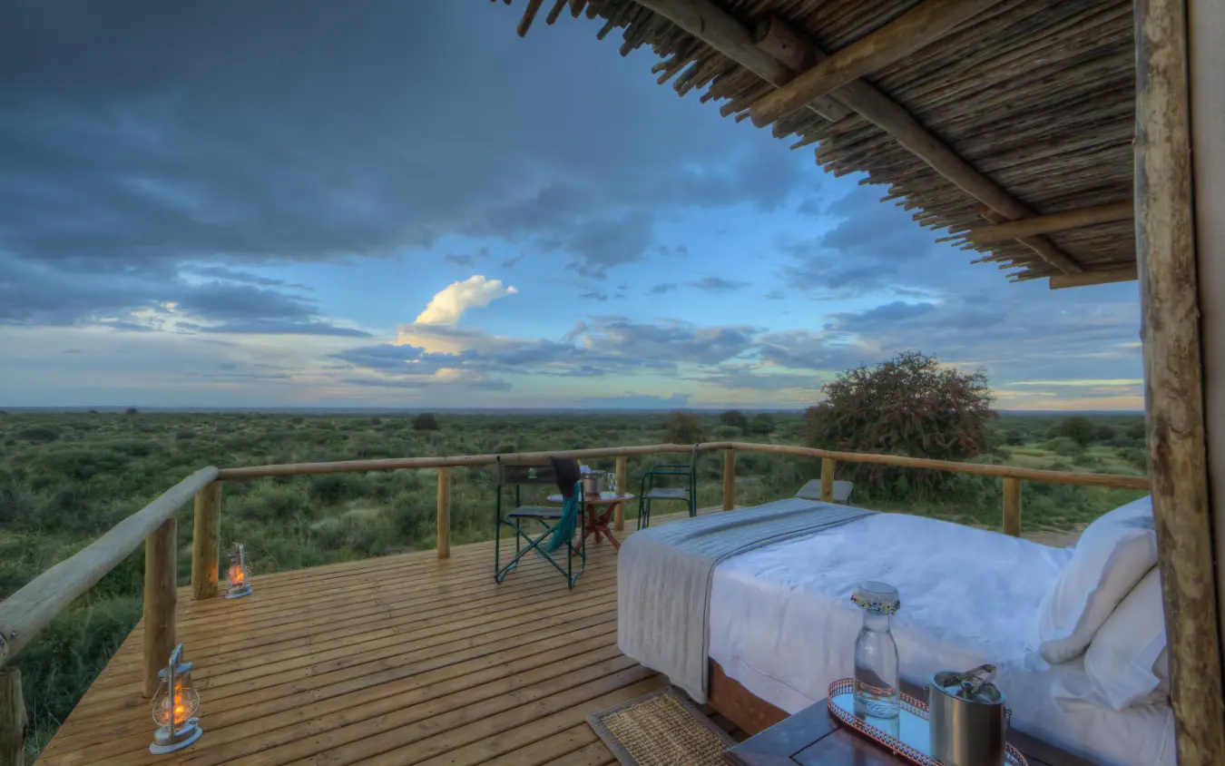 Bedroom deck overlooking expansive savanna landscape at sunset, Dinaka, Central Kalahari, Botswana