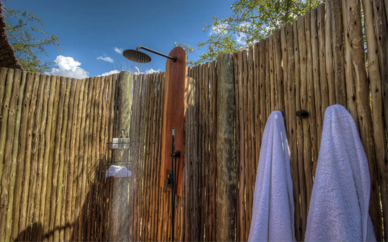Outdoor shower enclosure with wooden walls and towel, Dinaka, Central Kalahari, Botswana