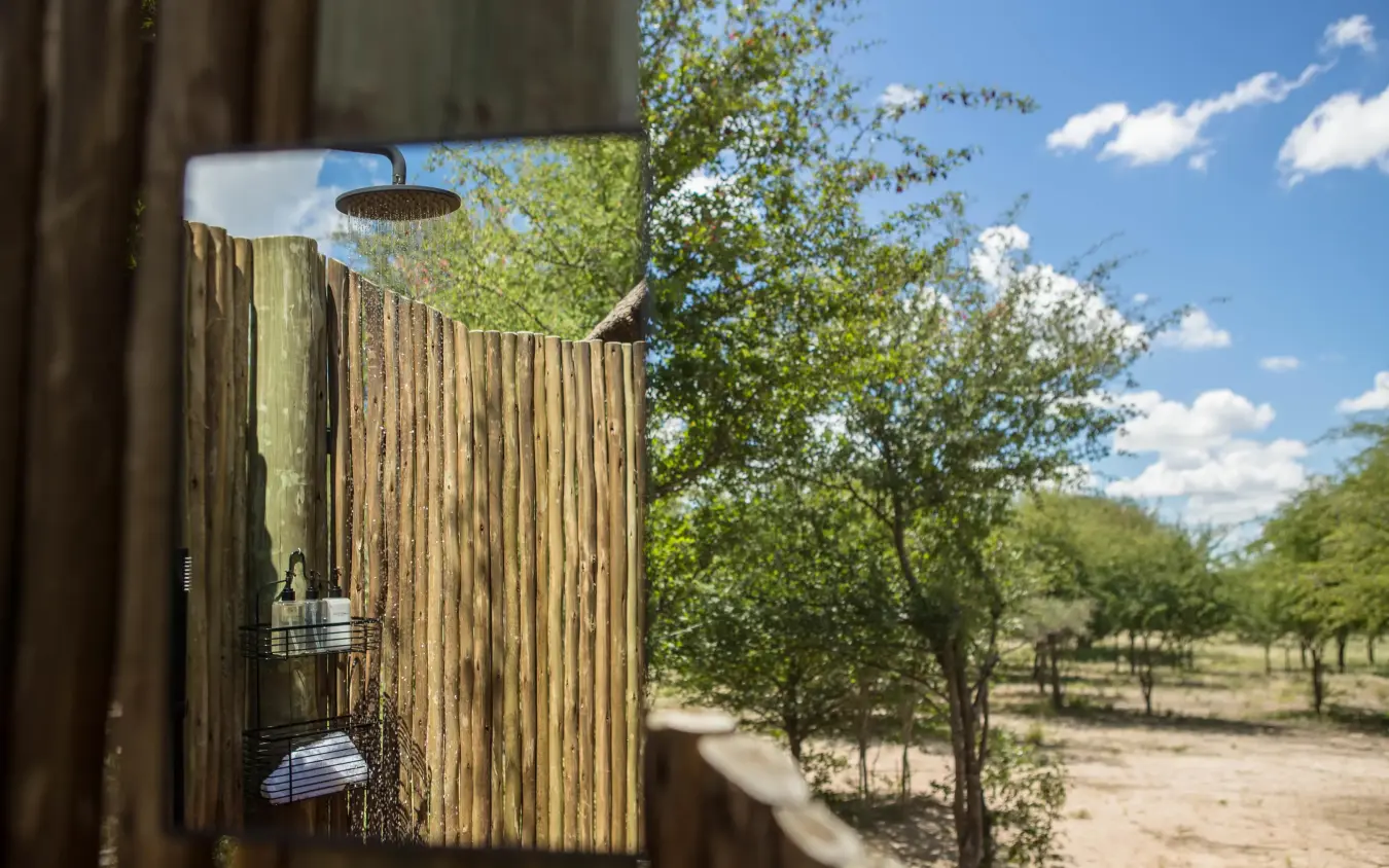 Outdoor shower enclosure with savanna landscape beyond, Dinaka, Central Kalahari, Botswana
