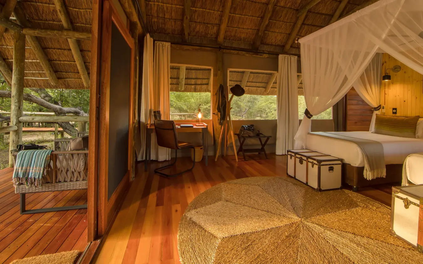 Luxury safari bedroom with wooden furnishings and open views, Dinaka, Central Kalahari, Botswana