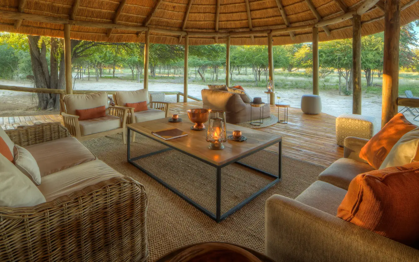 Riverside lounge with wicker seating and water views, Dinaka, Central Kalahari, Botswana