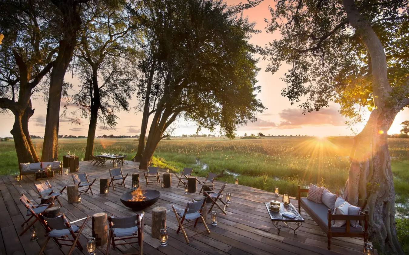 Wooden deck with seating area overlooking wetland at sunset, Duba Plains, The Okavango Delta, Botswana