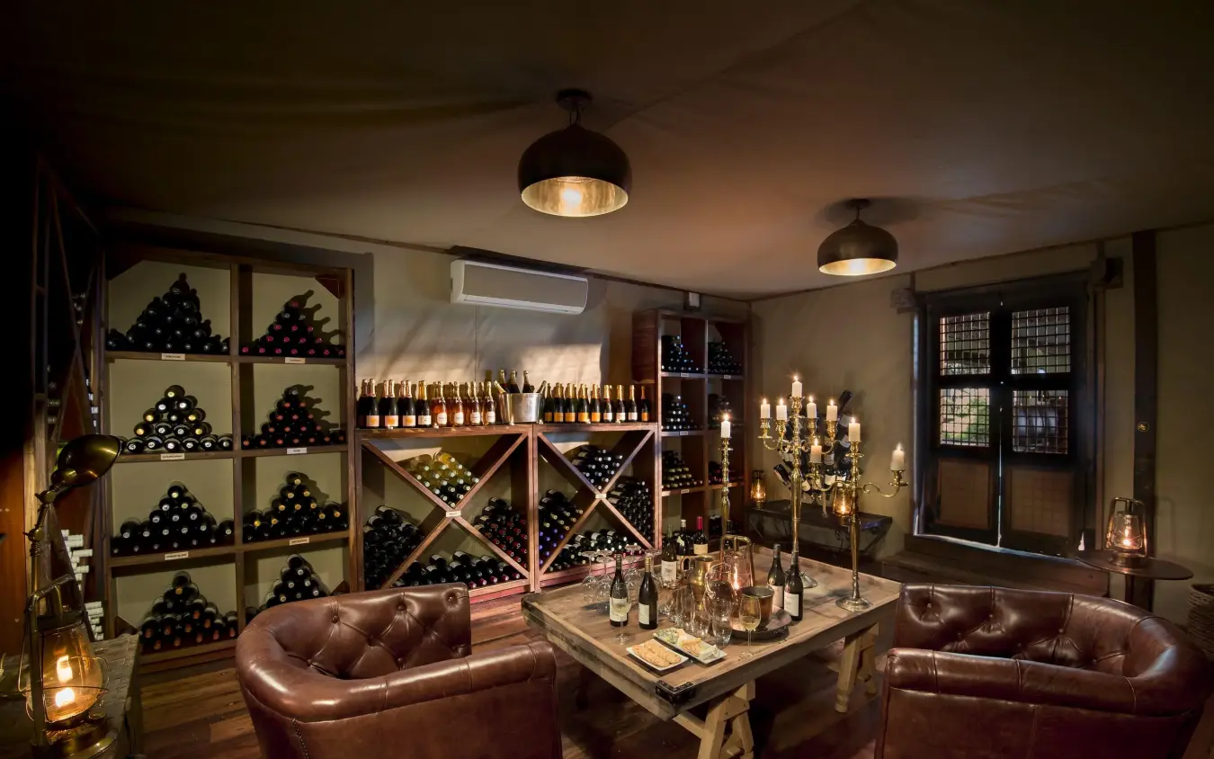 Wine cellar lounge with leather seating and bottle storage, Duba Plains, The Okavango Delta, Botswana