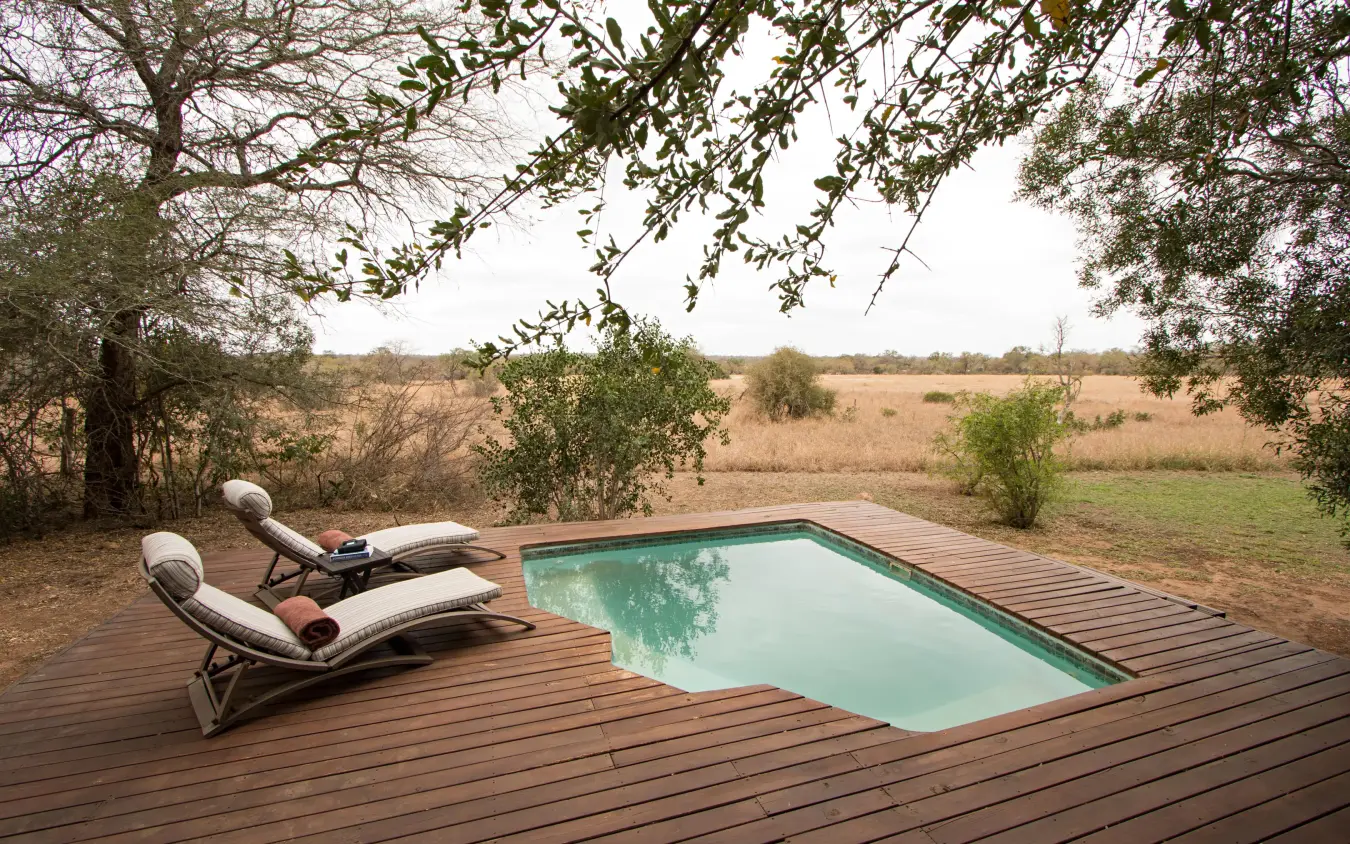 Swimming pool on wooden deck overlooking savanna landscape, Duba Plains, The Okavango Delta, Botswana